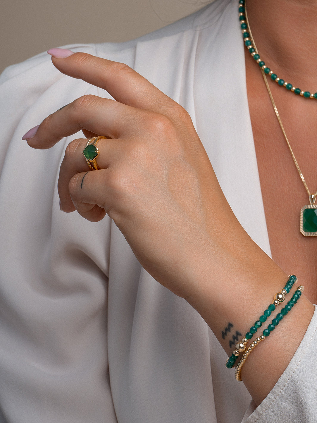 gouden armbandenstack met groene onyx edelsteen