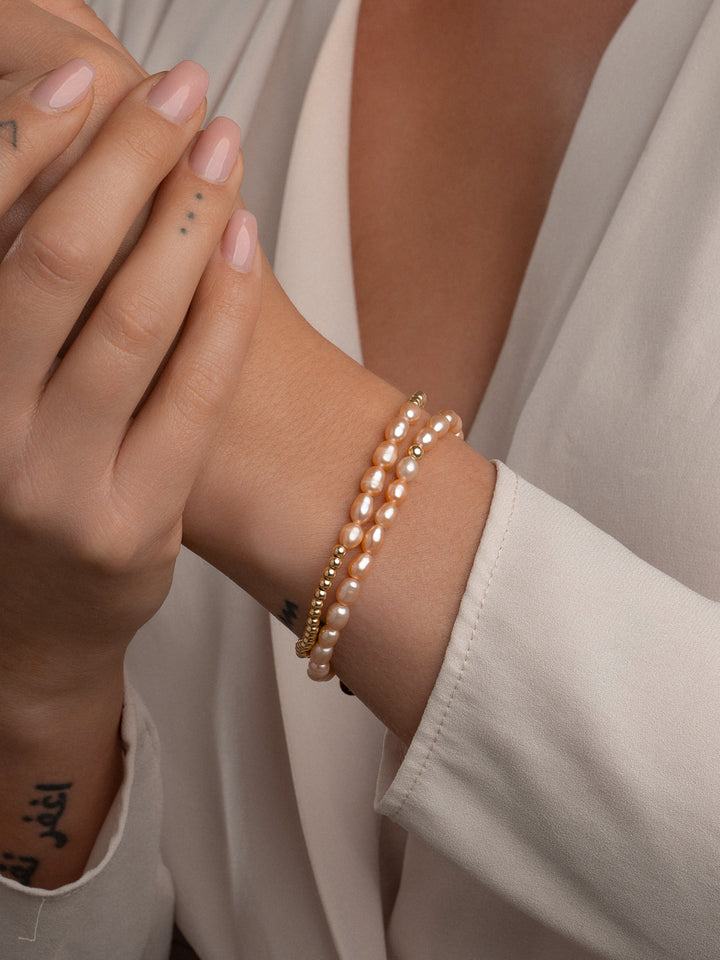 Sparkling gouden armband met peach kleurige parels #kleur_goud