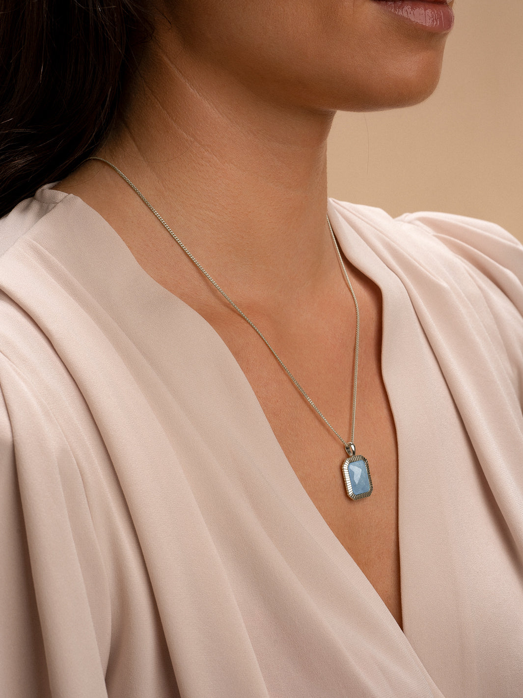 Vrouw met zilveren baguette pendant blue lace agate edelsteen aan gourmette-ketting #kleur_zilver
